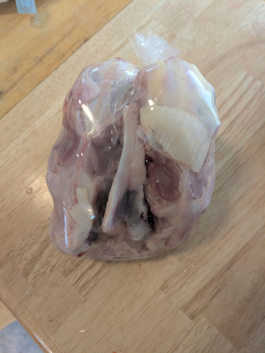 3 chicken carcasses packaged in a plastic bag. Corn free, soy free pasture raised chicken.